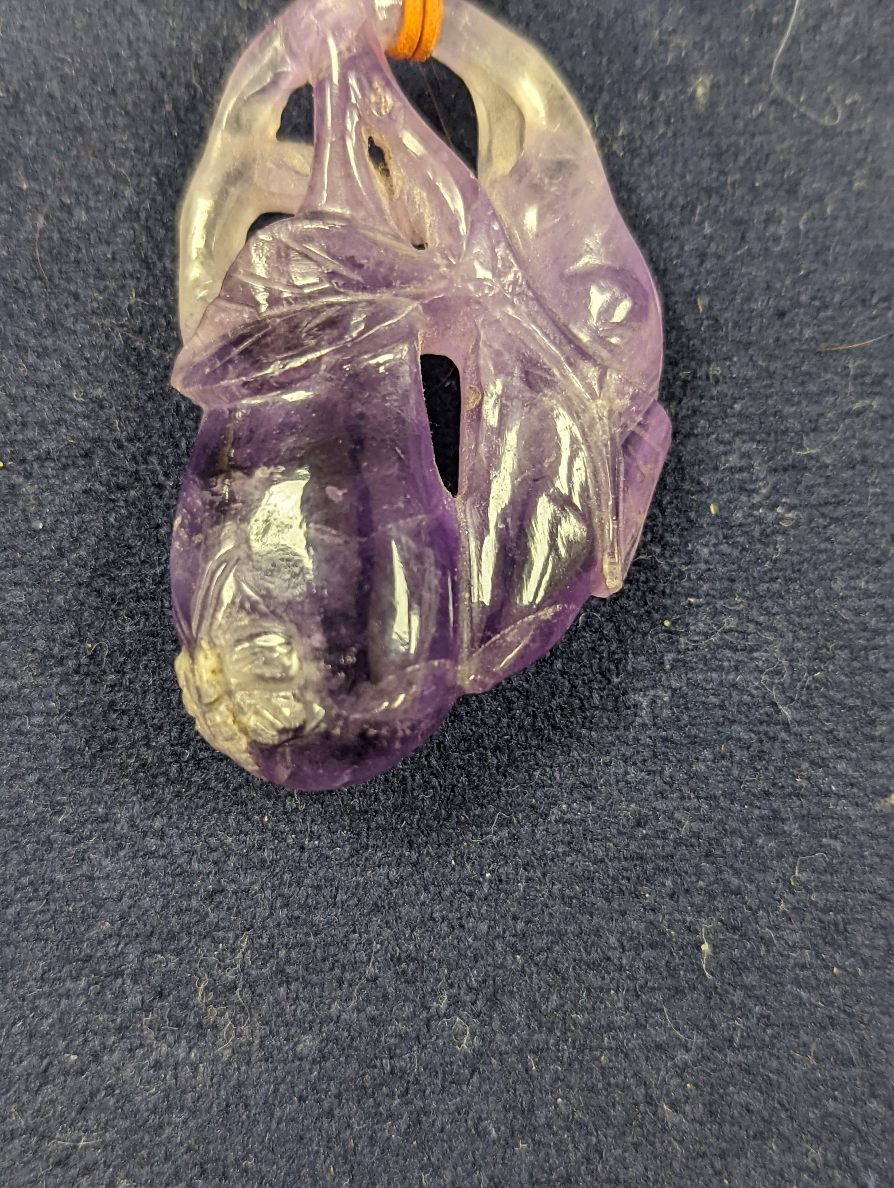 A 19th century Chinese carved amethyst pendant, 5cm on an ornate cord
